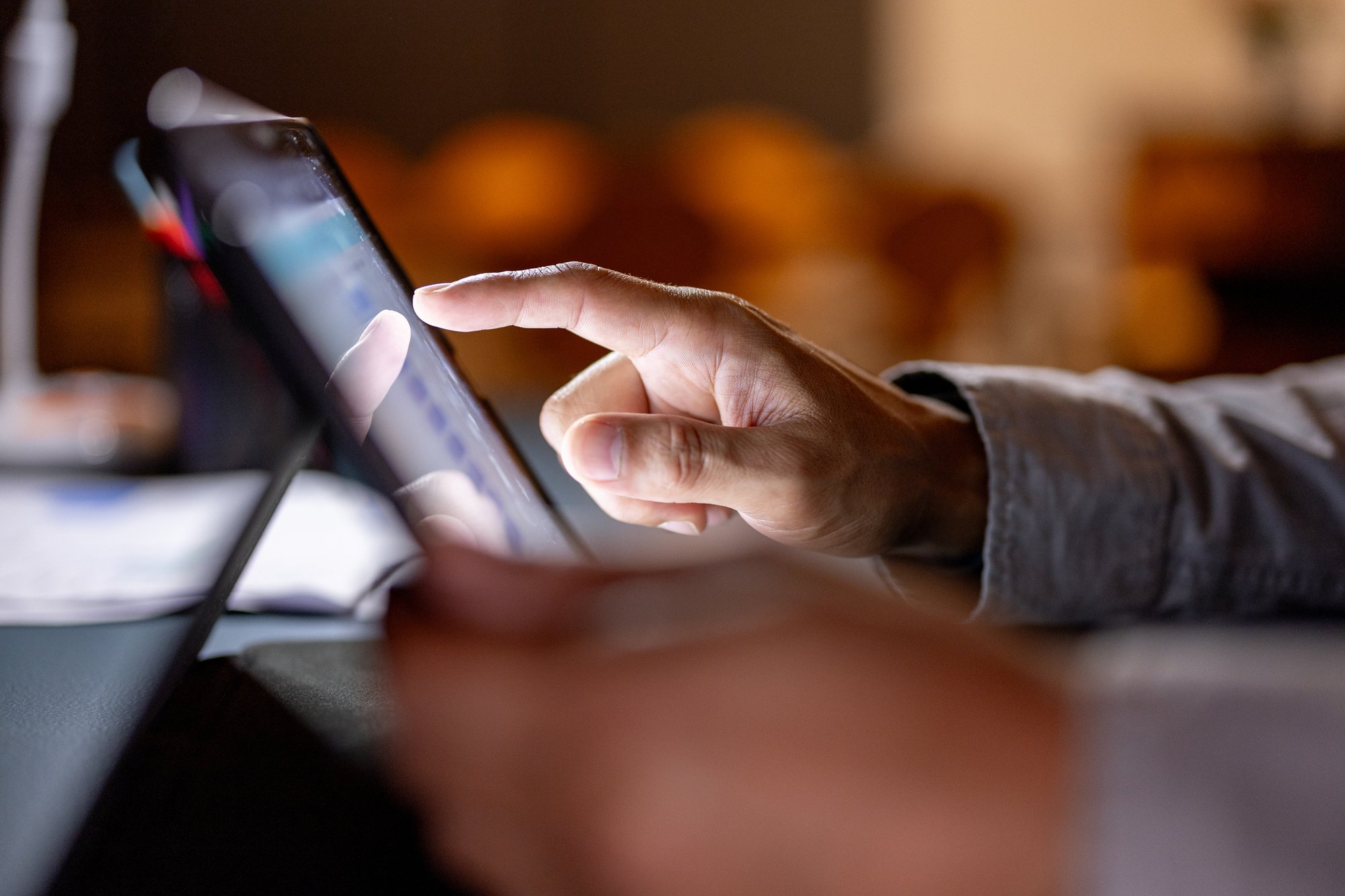 Close up of person using tablet touch screen in dim room