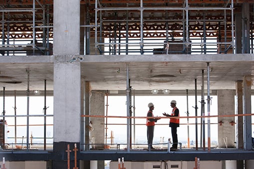 Construction workers talking inside partially-completed high rise