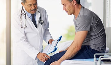 Doctor diagnosing patient's knee pain