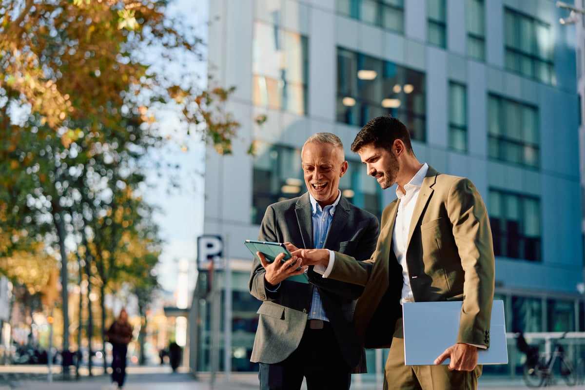 Workers reviewing information on iPad outside of office building