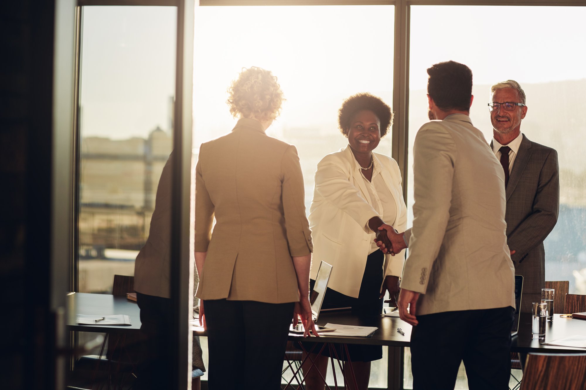 Office workers meeting at sunset, shaking hands