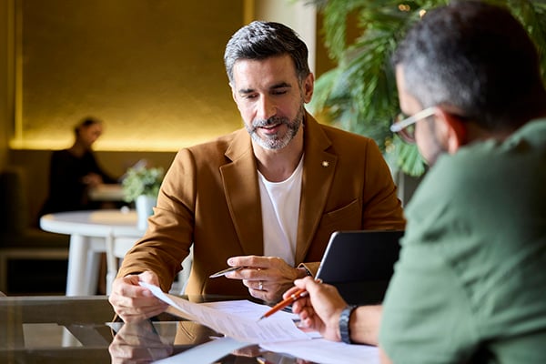 Two men going over paperwork in cafe