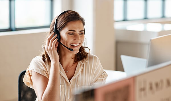 Woman working in call center, smiling while talking to customer