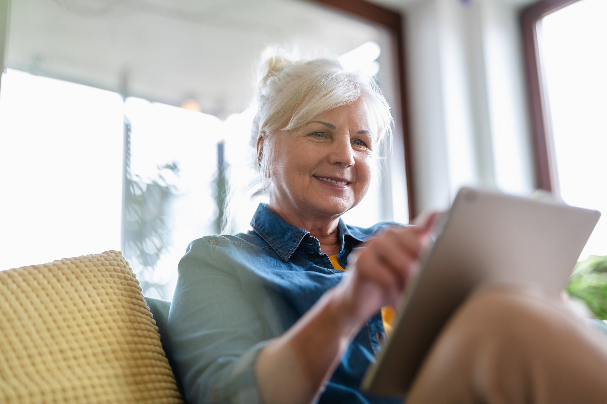 Older woman filling in form on clipboard in doctor's office