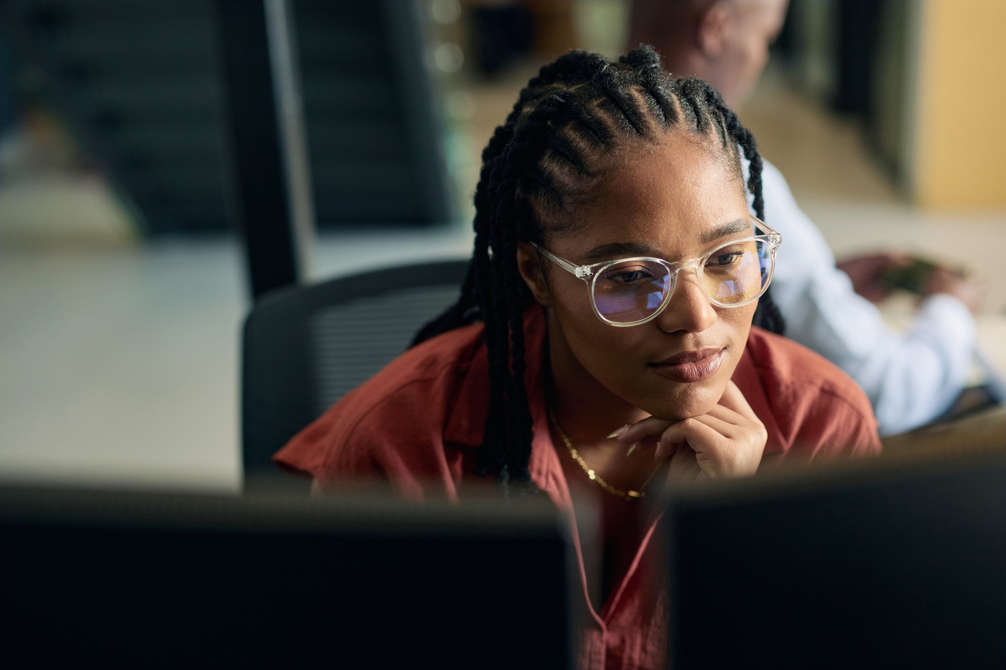 Woman working in office, using two computer monitors